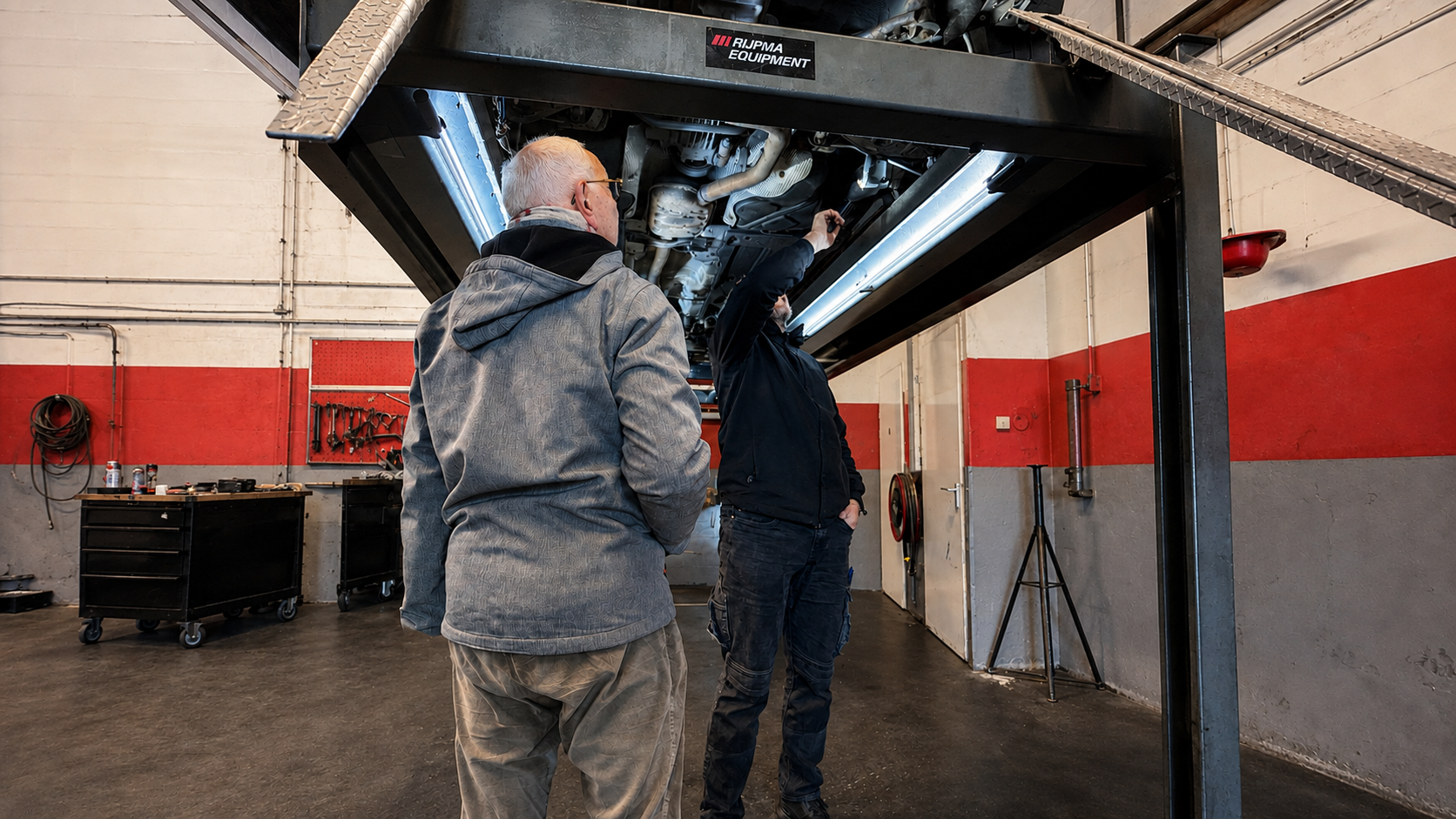 Een auto wordt bekeken op de hefbrug bij Garage Nieuw West